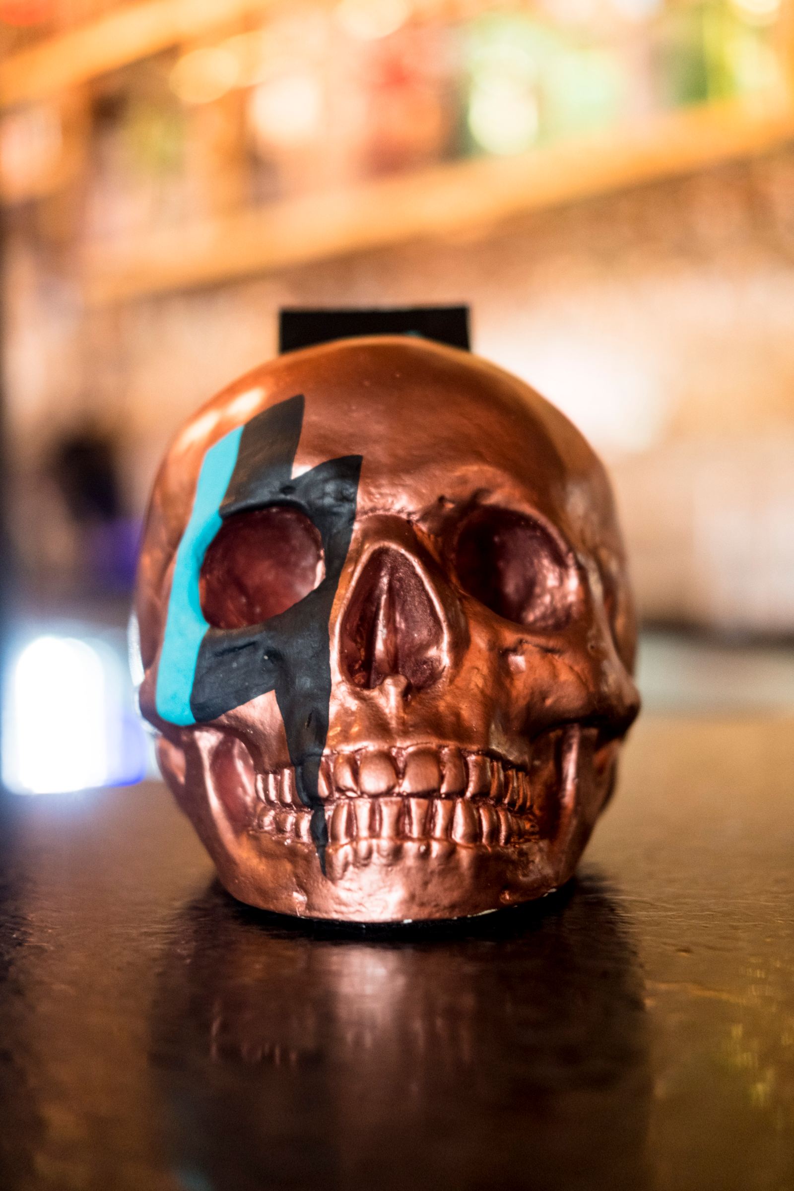 Calavera de cobre con el rayo de Bowie pintado en la cara